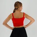 Czerwony top taneczny Corset Glow Red dla dziewczynki z połyskującą tkaniną i wstawkami z siatki imitującymi gorset.