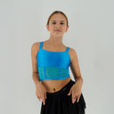 Niebieski top taneczny Corset Glow Blue dla dziewczynki z turkusowymi wstawkami z siatki imitującymi gorset.
